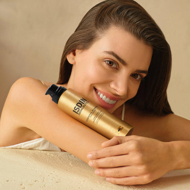 Modelo sosteniendo el envase dorado de ISDIN Isdinceutics Essential Purifier